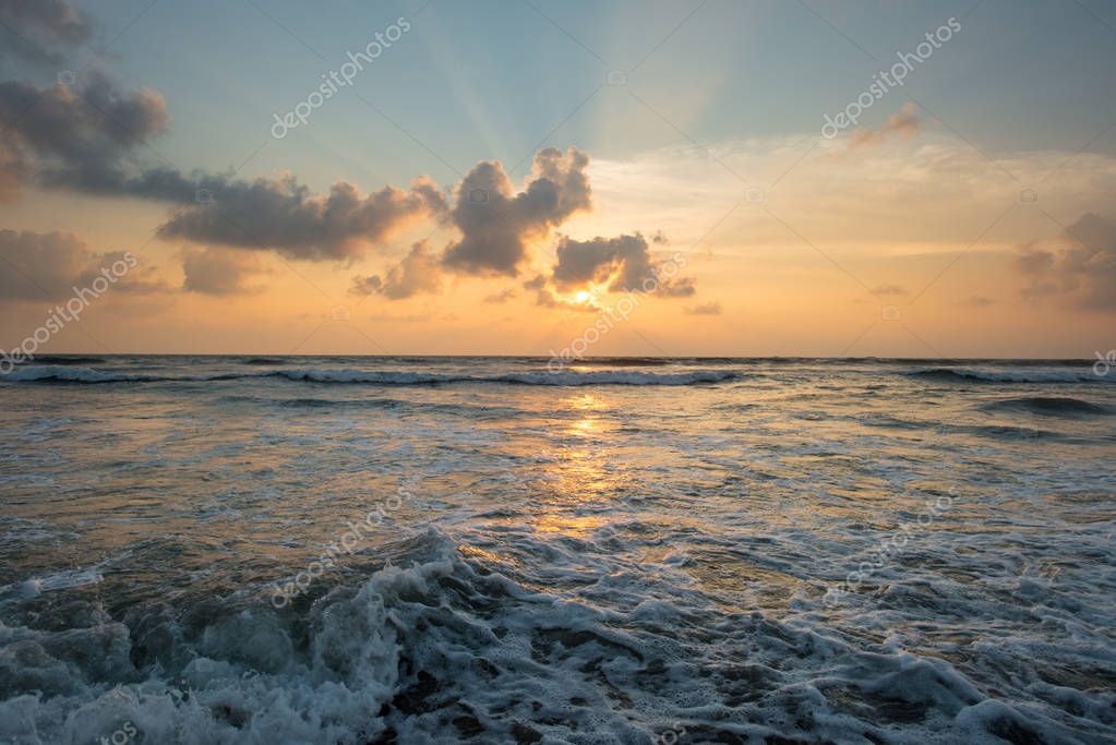 Plage au coucher du soleil avec la mer calme
