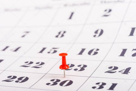 Main entourant un calendrier mural avec une date entourée